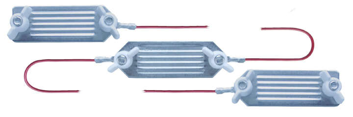 448359 Drei metallische Verbindungselemente mit roten Kabeln, die parallel angeordnet sind.